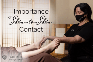a masseuse giving a massage on feet: text: importance of skin-to-skin contact