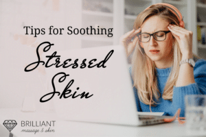 White girl in blue sweat shirt and eye glasses holds her temple with closed eyes: text: tips for soothing stressed skin